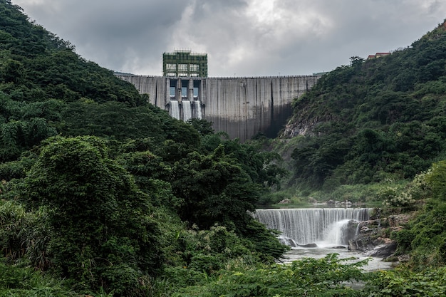Photo of a modern hydroelectric dam in the Amazon rainforest, with turbines generating clean energy and lush vegetation in the background, taken during a sunny day.
