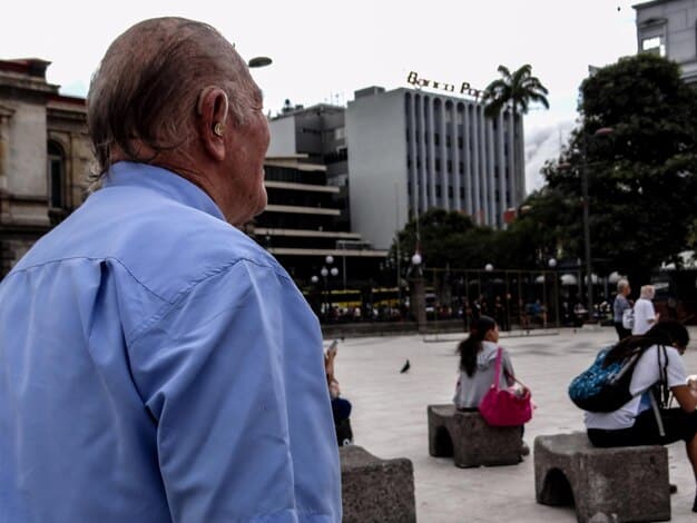 Photo of an unemployment line in Brazil, with people of diverse ages and backgrounds waiting anxiously, symbolizing the widespread impact of job loss.