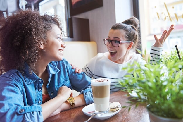 Two people having a casual conversation in English at a coffee shop, with smiles and relaxed body language.