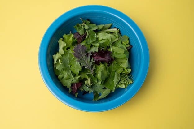 A top-down view of a colorful salad bowl filled with dark leafy greens like spinach and kale, along with vibrant additions like bell peppers, cherry tomatoes, and a light vinaigrette dressing. The focus is on the freshness and nutrient density of the ingredients, highlighting the health benefits of the salad.