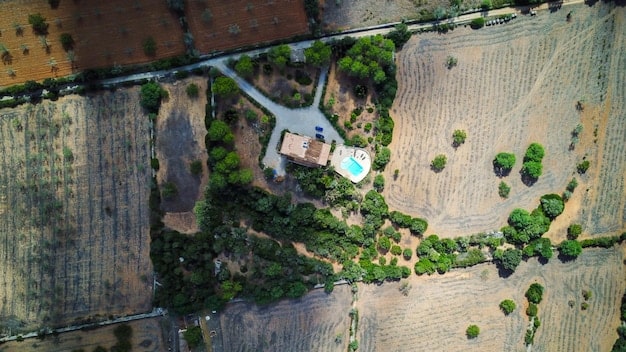 Aerial view of a modernized Brazilian farm showcasing the implementation of sustainable agriculture practices, including water management, crop rotation, and conservation tillage, under a clear sky with solar panels providing energy.