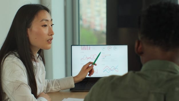 A teacher using an AI-powered dashboard to monitor student progress in real-time. The dashboard displays individual learning paths, performance metrics, and suggested interventions. Students are visible in the background, engaged in different learning activities supported by the AI platform. The setting is a bright, modern classroom with diverse students.