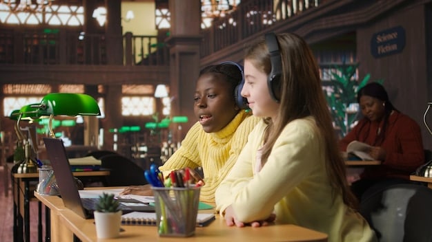 Diverse group of students are studying in a classroom. They are all wearing headphones and looking at their computers. The teacher is helping one of the students with her work. The scene emphasizes collaborative learning and modern education which is important for them to learn English efficiently.