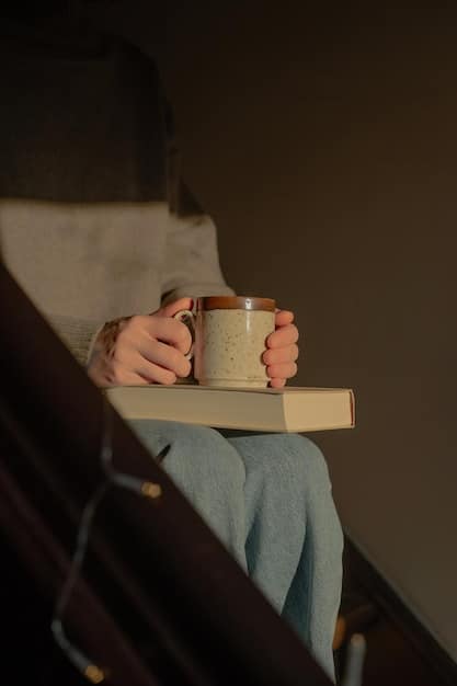 A person winding down for bed with a cup of herbal tea and a book in a dimly lit room.