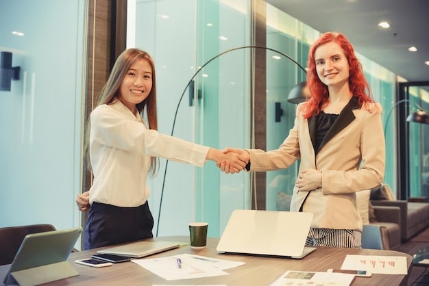 A woman confidently shaking hands with a hiring manager after a successful salary negotiation, both smiling in a bright and modern office environment, symbolizing a win-win outcome.